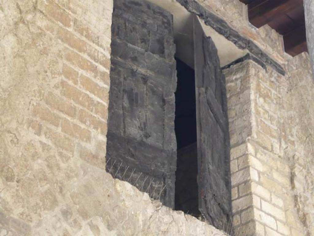 Decumanus Maximus, Herculaneum. August 2013. Detail of window shutter of carbonised wood, above doorway numbered 4. Photo courtesy of Buzz Ferebee.